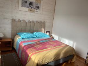una camera con un letto con una coperta colorata di Manurêva - Chambre d'hôte en coeur de ville a Dinan