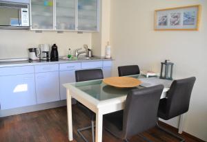 a kitchen with a table and chairs and a sink at Nautor Nautor in Norderney