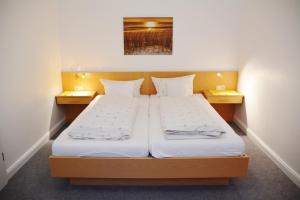 a bedroom with two beds and two night stands at Ferienhaus Pauls Ferienhaus Pauls, Whg 03 in Norderney