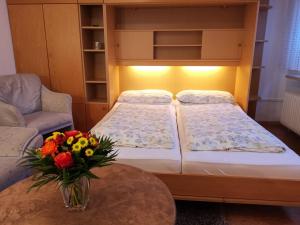 a bed and a table with a vase of flowers at Haus Forner Forner Bungalow in Norderney