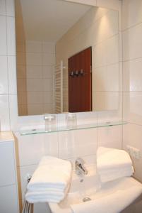 a bathroom with a sink with a mirror and towels at Alte Teestube Alte Teestube 14 in Norderney
