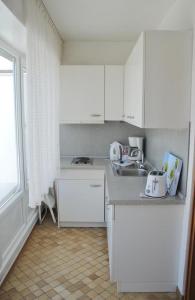 a kitchen with white cabinets and a sink at Alte Teestube Alte Teestube 14 in Norderney