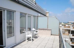 a patio with a table and chairs on a balcony at Alte Teestube Alte Teestube 14 in Norderney