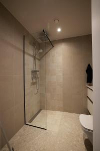 a bathroom with a glass shower with a toilet at Kastani Apartments in Rakvere