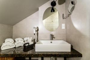 a bathroom with a sink and a mirror and towels at Rasta Maidan Hotel in Tbilisi City