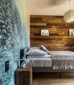 1 dormitorio con 1 cama y pared de madera en TATANKA Dom w Puszczy, en Białowieża
