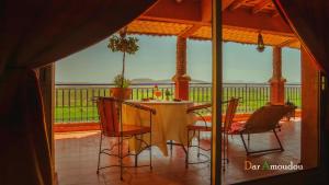 a porch with a table and chairs and a view of the ocean at Dar Amoudou in Ouarzazate