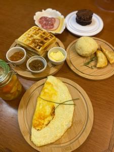 a table topped with plates of breakfast foods and waffles at Lala Haus Gramado in Gramado