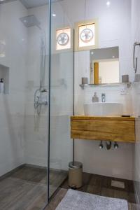 W łazience znajduje się umywalka i przeszklony prysznic. w obiekcie My Way w mieście Ras al-Chajma