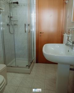 een badkamer met een douche, een wastafel en een toilet bij Smart and Sea Gardens in Tortoreto Lido