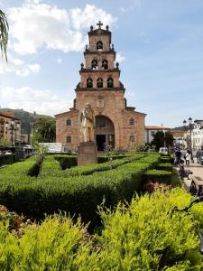a statue in front of a building with a tower at La Playina in Cangas de Onís