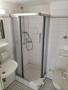 a bathroom with a shower and a toilet and a sink at DRK-Tagungshotel-Dunant in Münster