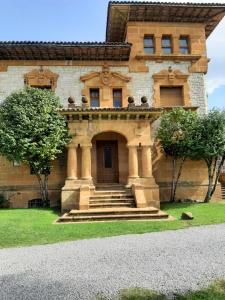una casa de piedra con una puerta principal y escaleras en La Playina, en Cangas de Onís