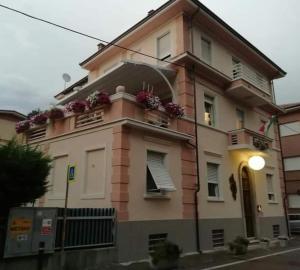 um edifício rosa com flores na varanda em La pajassa 22 em Alba