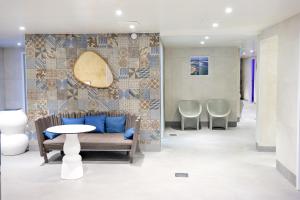 a living room with a blue wall and a blue bench at Hôtel & Spa Les Bains d'Arguin by Thalazur in Arcachon