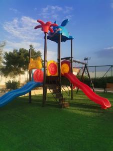 a playground with a slide in a park at استراحة الأسطورة AlAstura rest in Al Ḩamrāʼ