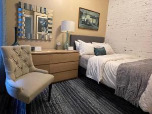 a hotel room with two beds and a chair at 2F Chicago's Little Italy near West Loop & Downtown in Chicago