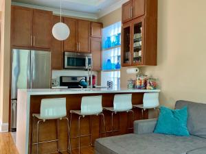 a kitchen with a bar with white chairs and a couch at 2F Chicago's Little Italy near West Loop & Downtown in Chicago