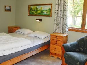 um quarto com uma cama, uma cadeira e uma janela em Holiday home Oldedalen em Briksdalsbre