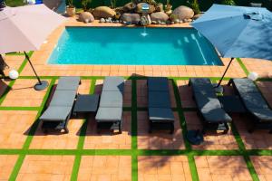 a pool with chairs and an umbrella next to it at A CASA DI JO in Calenzana