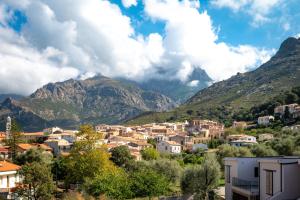 a small town in front of mountains with houses at A CASA DI JO in Calenzana