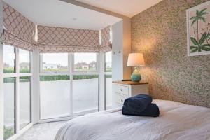 1 dormitorio con cama y ventana grande en Sandy Villa en Westgate on Sea