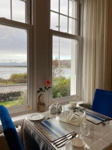 奧本的住宿－阿茲住宿加早餐旅館，一张带蓝色椅子的桌子和一张带两个窗户的桌子