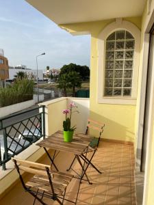 d'un balcon avec une table, deux chaises et une fenêtre. dans l'établissement Apartamento Rua do Sol by Localhosting, à Albufeira