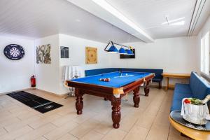 a living room with a pool table and a couch at Strandhotel Seeblick in Faulensee