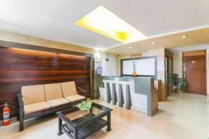 a living room with a couch and a table at Hotel City Garden in Madgaon