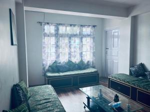 a living room with a couch and a window at Norbus Homestay in Darjeeling