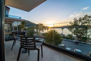 a balcony with two chairs and a view of the water at Ansira Suites in Fethiye