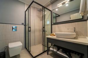 een badkamer met een douche, een wastafel en een toilet bij Ansira Suites in Fethiye