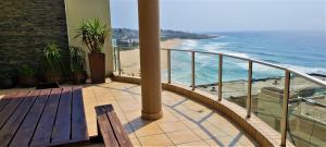 a balcony with a bench and a view of the ocean at Santorini 402B in Margate