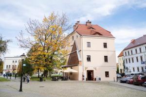 a large white building with a red roof on a street at Katedralna Apart's Legnica in Legnica