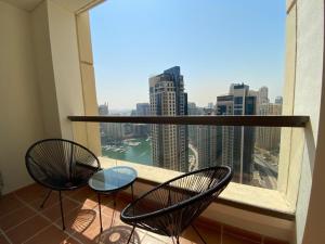 a balcony with two chairs and a view of a city at Al Mashreq 2 BR Rimal 1, City View - JBR in Dubai