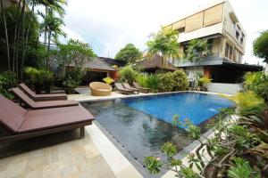 a swimming pool in front of a building at Tori Inn in Sanur