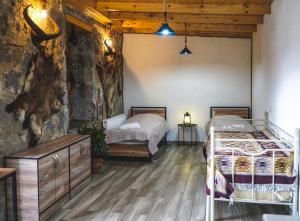 1 Schlafzimmer mit 2 Betten und einer Steinmauer in der Unterkunft House 54 in Kazbegi