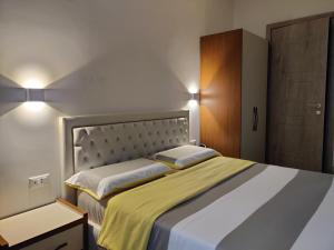 een slaapkamer met een groot bed en een gele deken bij B&B Crocevia in Trieste