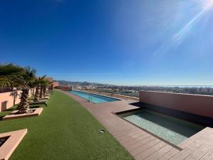 una piscina al lado de un edificio en Sky Garden & seasonal pool views by ELE Apartments, en Málaga