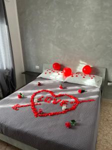 a heart made out of red decorations on a bed at Mondo House in Fiumicino