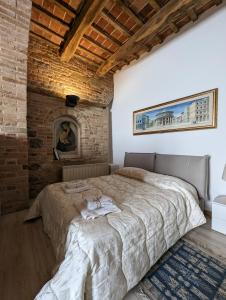 1 dormitorio con 1 cama grande en una pared de ladrillo en Casa di Clara in Piazza, ideale per smartworking, en Amandola