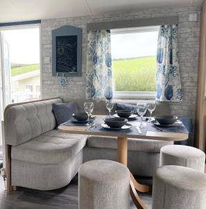 sala de estar con mesa y sofá en Newquay Bay Resort - Sea Breeze 61, en Newquay