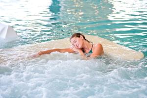 a woman in the water in a swimming pool at Thalazur Arcachon in Arcachon