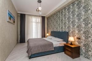 a bedroom with a bed with a blue head board at Luxury Landing ll in Tbilisi City