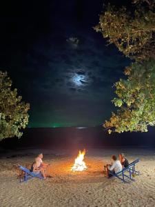 俊島的住宿－俊穆島陽光微笑海灘旅館，一群人坐在海滩上的火堆旁