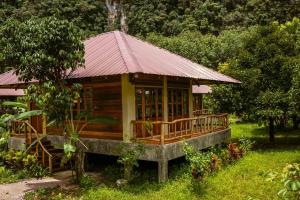 a small wooden house with a red roof at Monkey Mansion - Jungalows & Tours in Khao Sok