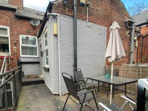 a patio with a table and an umbrella at New York Apartment in Heeley