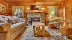 a living room with a couch and a stone fireplace at Dream Catcher Cabin - Meredith Lodging in Brightwood
