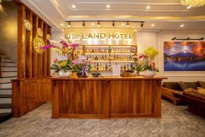 a lobby of a hotel with a bar with flowers at The Land Hotel & Apartment in Vung Tau